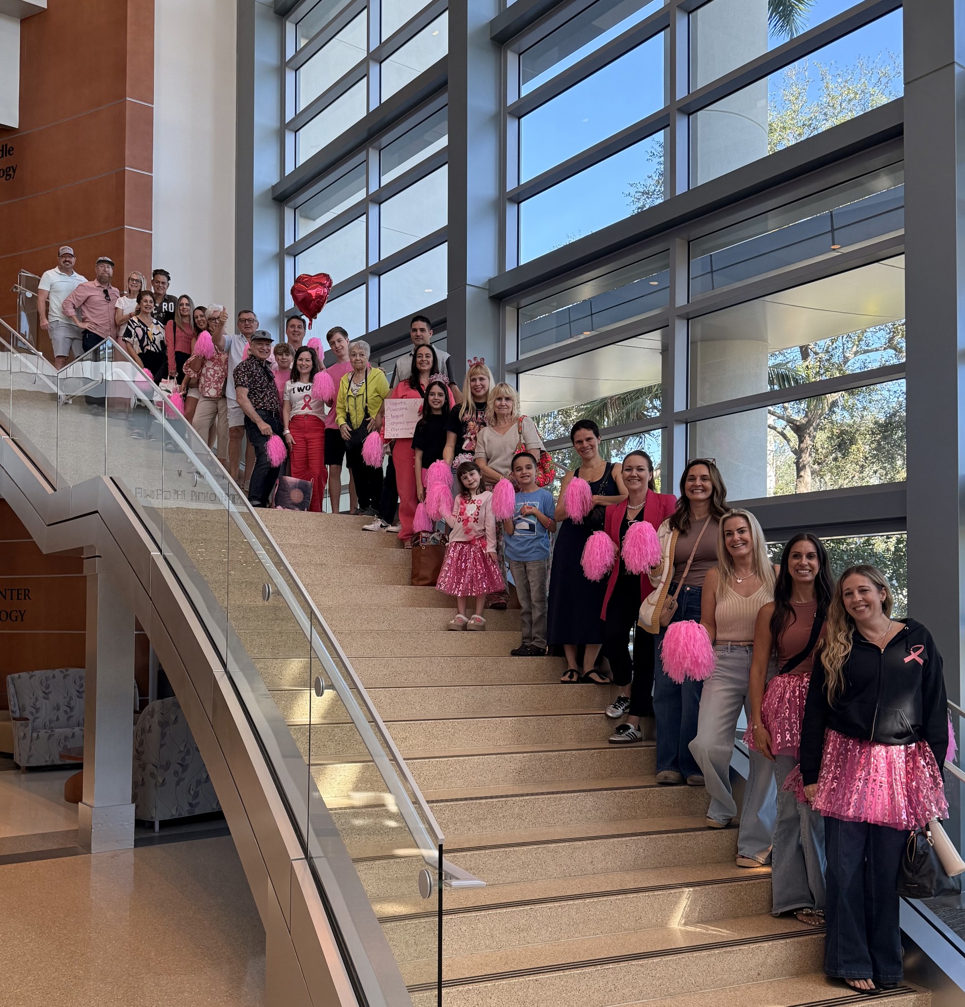 Maegen on the stairs at Lynn Cancer Institute with the friends and family who came to see her ring the bell after two years of battling breast cancer.
